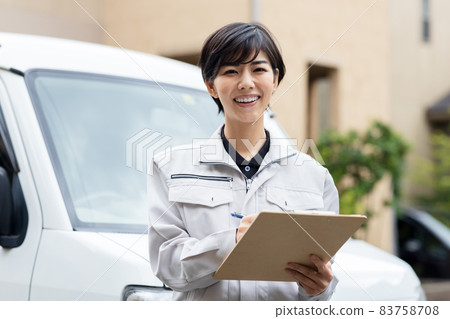 A woman in work clothes visiting a house A woman in work clothes visiting a house 83758708