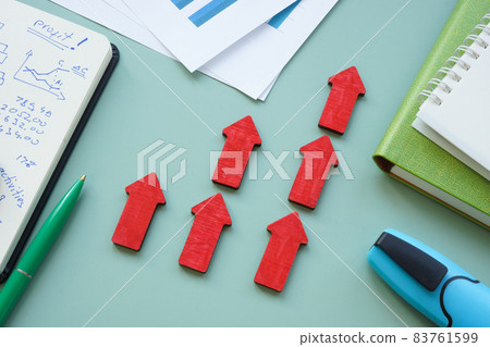Business success concept with raised red arrows and financial report. Business success concept with raised red arrows and financial report. 83761599