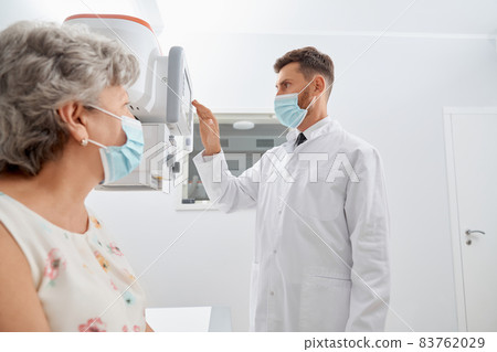 Radiologist touching screen of modern equipment starting scanning..  83762029