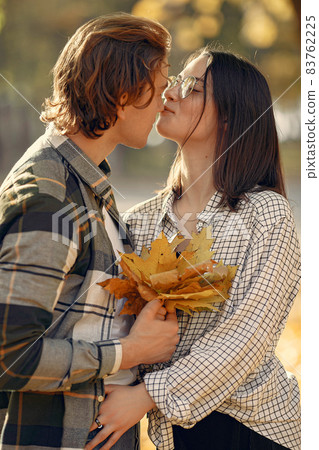 Beautiful couple spend time in a autumn park Beautiful couple spend time in a autumn park 83762225