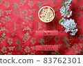 Golden tiger symbol and branch of white sakura cherry blossom on red fabric with traditional chinese ornament birds and dragons. Chinese New Year of the Tiger 2022. Translation: year of the tiger 83762301