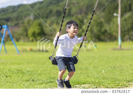 A boy riding a swing A boy riding a swing 83762817