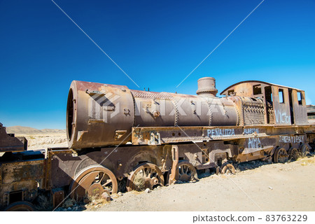 Rusty old steam train in Bolivian desert - train cemetery in Uyuni 83763229