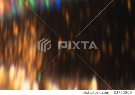 Lens flare overlay. Blur sparks. Disco illumination. Defocused golden orange colorful light flecks glow on dark night abstract background. 83763869