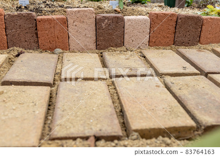 A garden where bricks are lined up by DIY to make a small diameter and a flower bed A garden where bricks are lined up by DIY to make a small diameter and a flower bed 83764163
