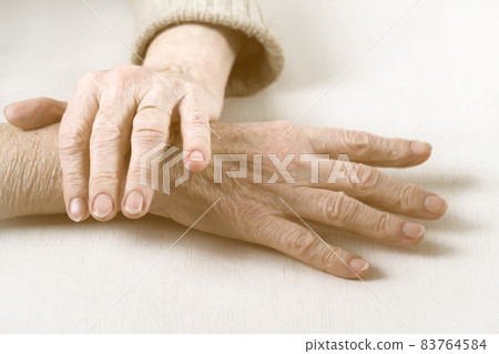 The hands of an elderly well-groomed woman in a casual sweater. The hands of an elderly well-groomed woman in a casual sweater. 83764584