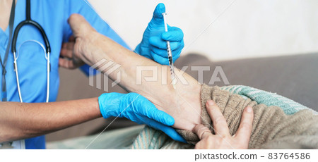 The nurse makes an injection with the vaccine to the patient at home. The nurse makes an injection with the vaccine to the patient at home. 83764586