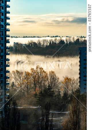 Foggy autumn morning in a town. Cityscape with residential buildings 83765587