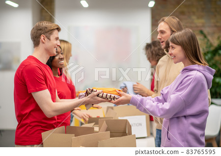 Workers of the non profit organization distributing donations Workers of the non profit organization distributing donations 83765595