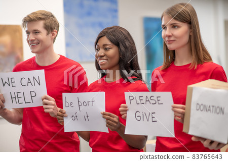 Young volunteers encouraging people to donate Young volunteers encouraging people to donate 83765643