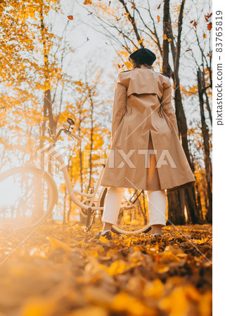 Young woman in classic trench coat rejoices autumn, freedom and beautiful nature. Amazing scene of Young woman in classic trench coat rejoices autumn, freedom and beautiful nature. Amazing scene of 83765819