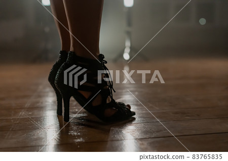 Woman in heels standing in smoky dancing studio with lamps. Girl with sexy slender legs. Modern Woman in heels standing in smoky dancing studio with lamps. Girl with sexy slender legs. Modern 83765835