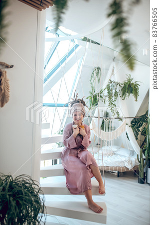 Young woman with a headwear sitting with yarn in hands Young woman with a headwear sitting with yarn in hands 83766505
