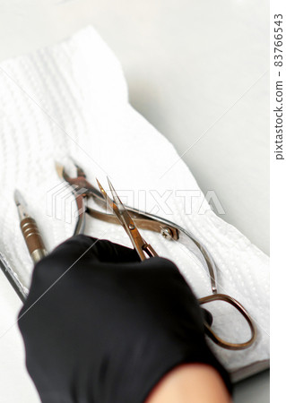 Professional manicure master prepares nail care tools on a white background with copy space. Professional manicure master prepares nail care tools on a white background with copy space. 83766543