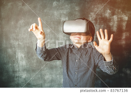 Happy stylish kid boy in VR glasses putting hands out. Excited shocked child isolated on black background Happy stylish kid boy in VR glasses putting hands out. Excited shocked child isolated on black background 83767136