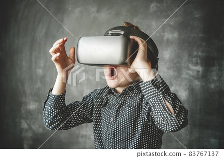 Shocked kid in VR glasses watching travel video. School boy experiencing virtual reality Shocked kid in VR glasses watching travel video. School boy experiencing virtual reality 83767137