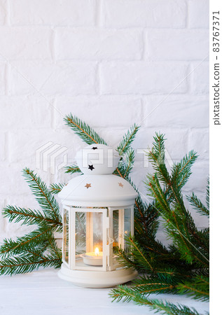 Scandinavian home decor. White lantern and fir branches. 83767371