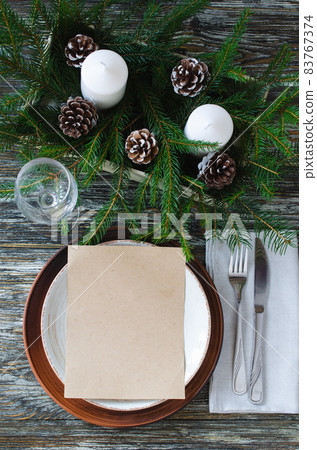 Christmas table setting with candles and fir branches Christmas table setting with candles and fir branches 83767374