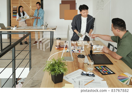 Young female designer or architect consulting with colleague 83767882