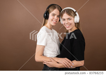 Two young twin females in headphones and t-shirts Two young twin females in headphones and t-shirts 83768233
