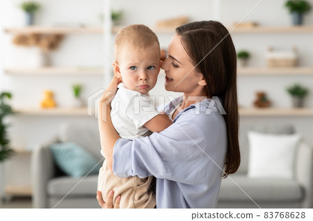 Mother's Care Concept. Beautiful Young Woman Holding Adorable Toddler Child In Hands, 83768628