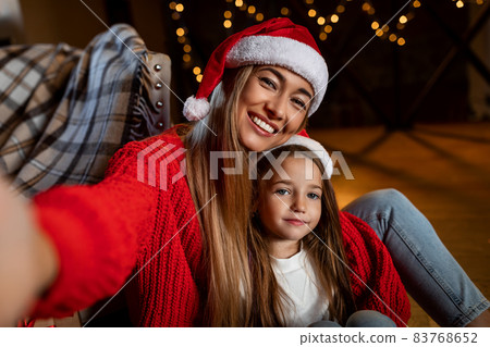 Pov of happy woman and daughter talking selfie at xmas 83768652