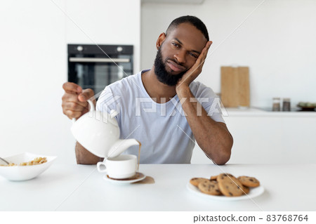 Black guy pouring coffee away from cup spilling hot drink 83768764