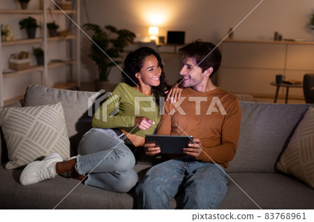 Cheerful Young Spouses Using Digital Tablet Together At Home Cheerful Young Spouses Using Digital Tablet Together At Home 83768961
