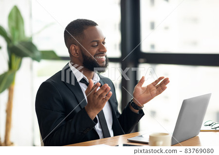 Black man having video call using laptop and talking Black man having video call using laptop and talking 83769080