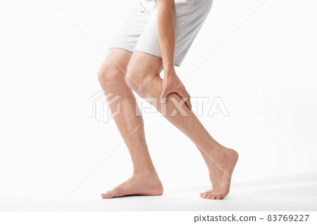Cropped millennial caucasian male athlete massaging his leg and suffering from shin pain Cropped millennial caucasian male athlete massaging his leg and suffering from shin pain 83769227