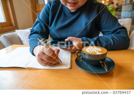 Surfing the Internet on smartphone and writing notes Surfing the Internet on smartphone and writing notes 83769437