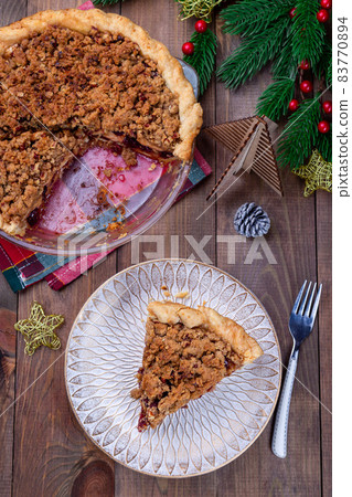Traditional American apple cranberry pie, topped with crumbled dough and pecan, vertical, top view Traditional American apple cranberry pie, topped with crumbled dough and pecan, vertical, top view 83770894