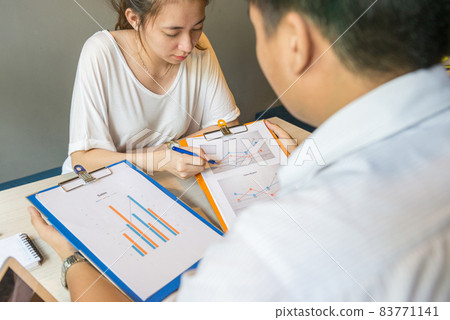 Young office woman working on sales data paperwork with her partner Young office woman working on sales data paperwork with her partner 83771141