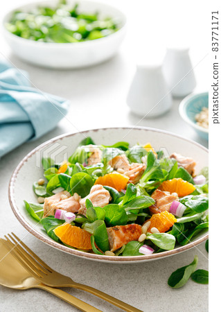 Christmas salmon orange salad with pine nuts, red onion and corn salad lettuce 83771171