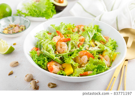 Grilled shrimp salad with avocado, mango, lettuce and pistachios, dressed with lime. Healthy food. Ketogenic diet. 83771197