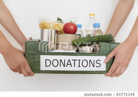 volunteers holding box filled with food donation. High quality beautiful photo concept volunteers holding box filled with food donation. High quality beautiful photo concept 83772148