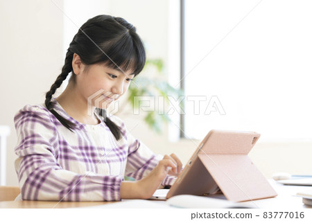 Girls in the upper grades of elementary school studying with a tablet 83777016