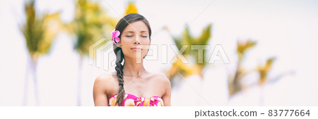 Wellness meditation Asian woman at spa resort meditating on Hawaii beach - relaxation, well-being healthy lifestyle. 83777664