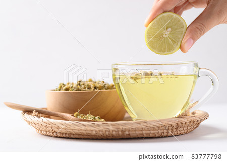 Chamomile tea with lemon and dried chamomile flowers on white background, Heaalthy herbal drink 83777798