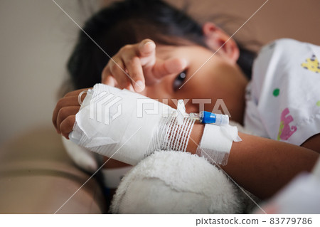 Sick kid feeling unwell lying down and hugging her doll in the bed while stay in private patient rooms in the hospital. Healthcare and lifestyle concept. Sick kid feeling unwell lying down and hugging her doll in the bed while stay in private patient rooms in the hospital. Healthcare and lifestyle concept. 83779786