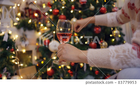 Woman drink red wine and decorate Christmas tree for Xmas and New Year party at home. Woman drink red wine and decorate Christmas tree for Xmas and New Year party at home. 83779953