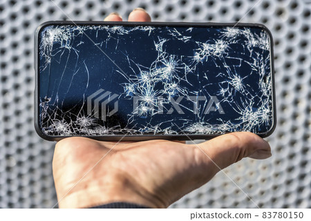 Smartphone fence background with broken screen after dropping Smartphone fence background with broken screen after dropping 83780150