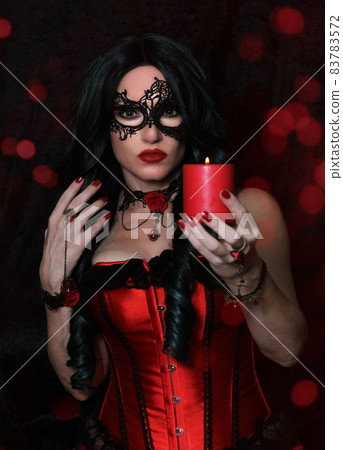Woman in Red Corset holding Candle With Red Bokeh Background Woman in Red Corset holding Candle With Red Bokeh Background 83783572