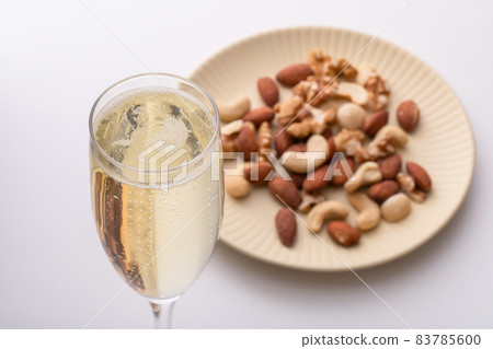 白桌上放著起泡酒和堅果 83785600