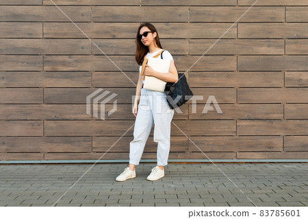 Photo of fascinating beautiful smiling charming young brunette girl wearing stylish clothes holding 83785601