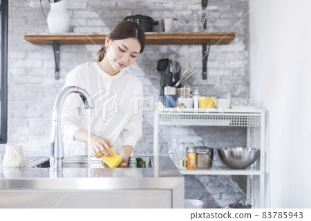 Woman washing dishes in the kitchen Woman washing dishes in the kitchen 83785943