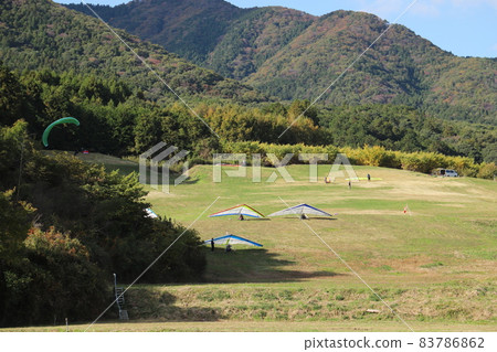 A hang glider flying at the foot of Mt. Tsukuba in the blue sky A hang glider flying at the foot of Mt. Tsukuba in the blue sky 83786862