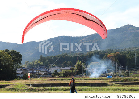 A hang glider flying at the foot of Mt. Tsukuba in the blue sky A hang glider flying at the foot of Mt. Tsukuba in the blue sky 83786863