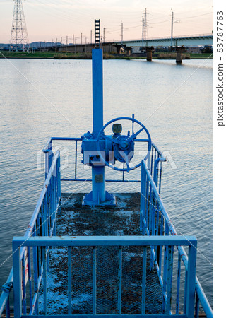 Silhouette of a blue lock handle illuminated by the setting sun 83787763