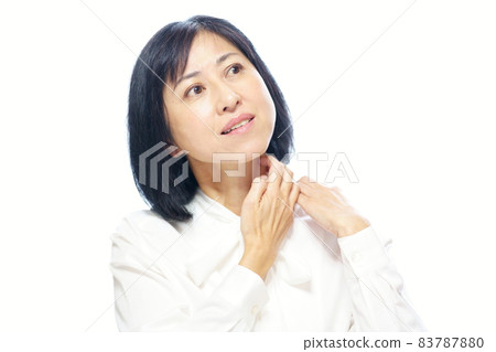 Middle-aged woman wearing a white bow blouse and scratching her neck Upper body white background Middle-aged woman wearing a white bow blouse and scratching her neck Upper body white background 83787880